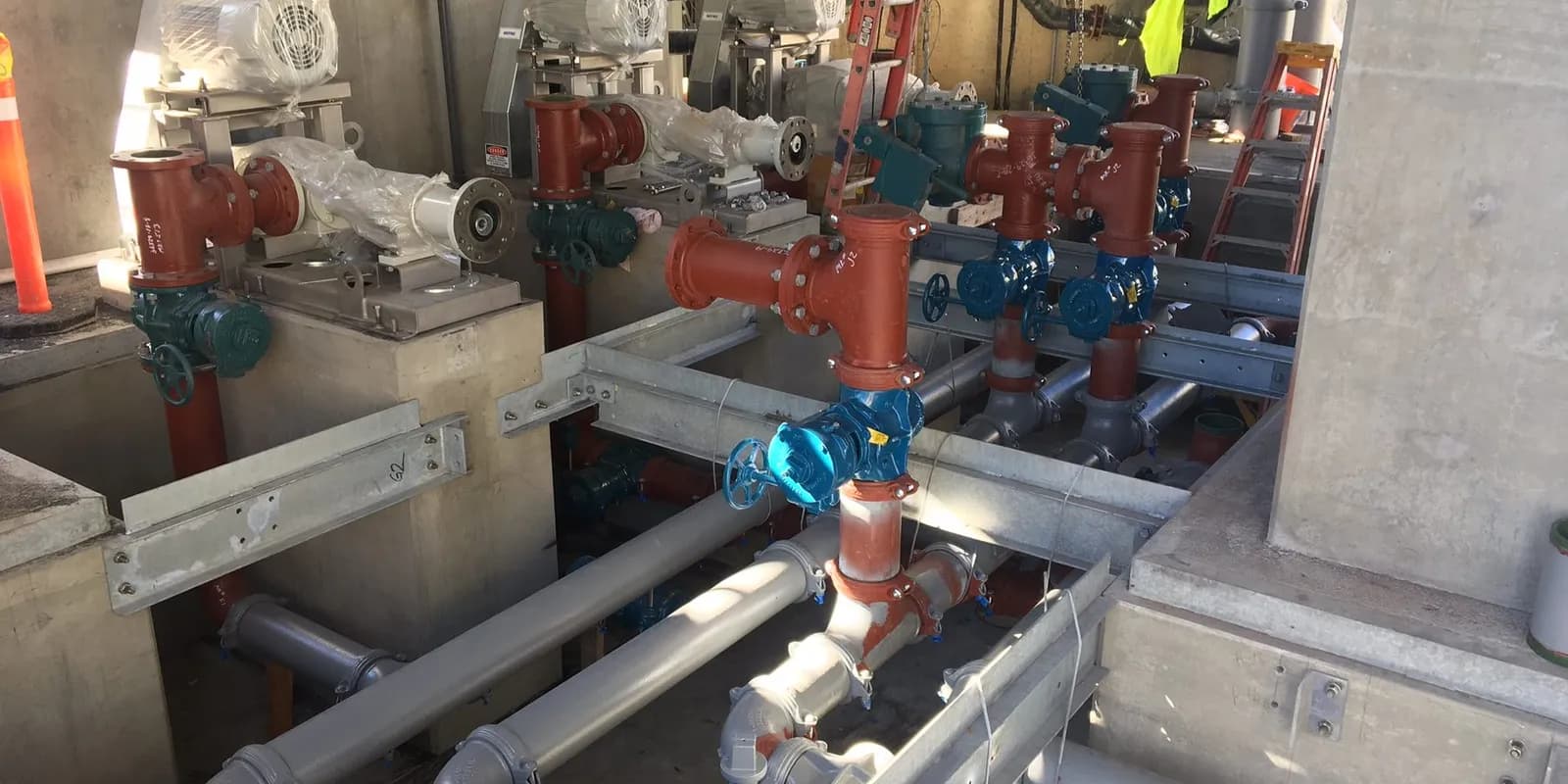 Red and blue valves and piping in a treatment plant control building on a CapFlo job.